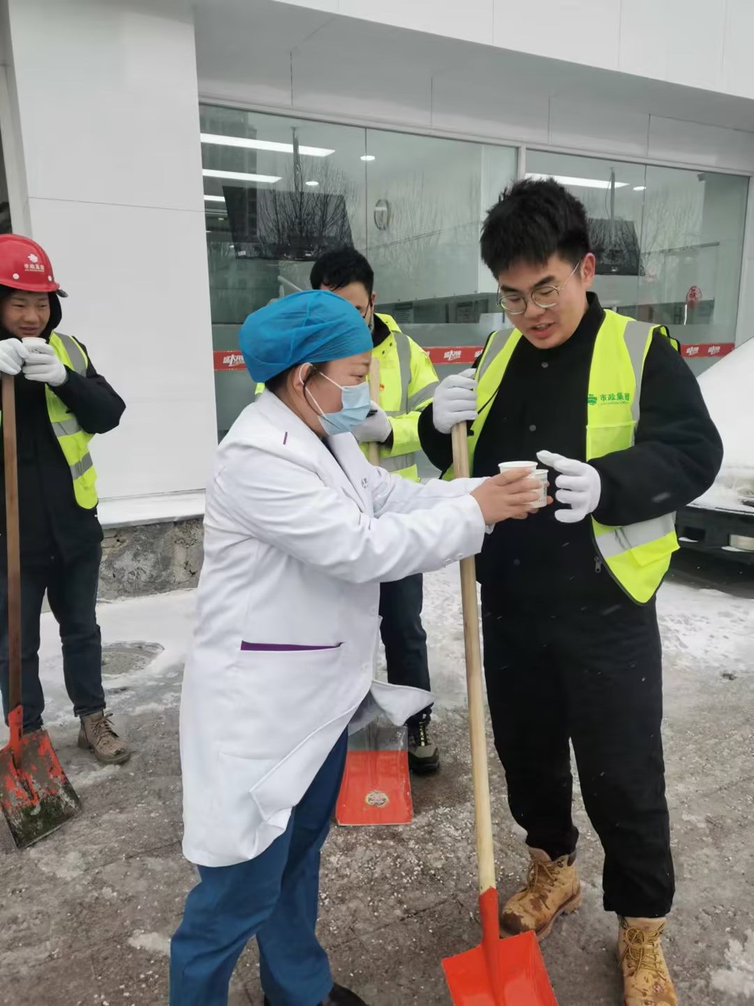 2月21日上午，青岛市政地铁5号线二标06工区项目部主动承担了合肥路站、滁州路站及其周边社区网点等区域的清雪除冰任务。他们用实际行动诠释着责任与奉献，确保居民安全出行，赢得了居民的好评，在清雪过程中，网点商家暖心的为项目部清雪人员端来热水。此次行动，体现了市政铁军精神，彰显了国企担当。.jpg